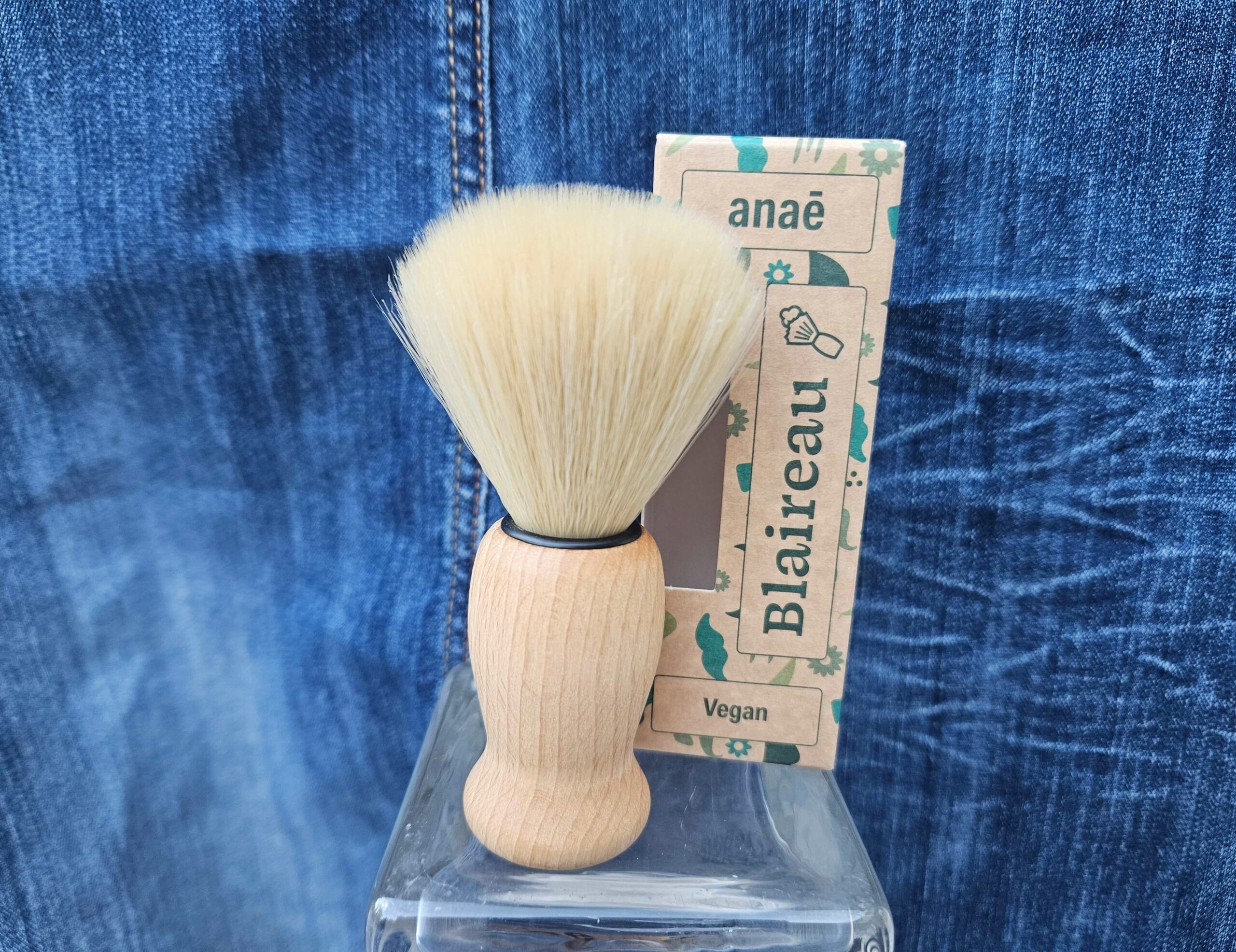 Accessoire zéro déchet de la savonnerie artisanale Sabuni & Cie. Blaireau vegan fabriqué en Europe. Eponge konjac sur fond bleu jeans.
