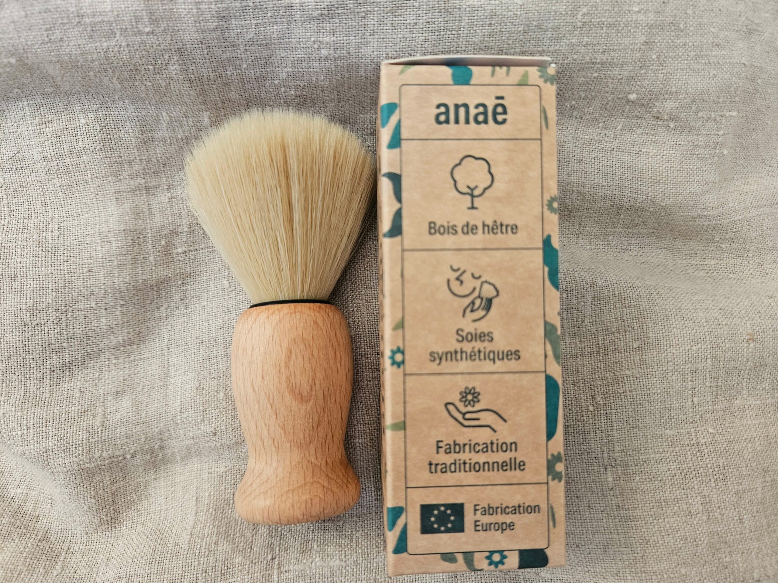 Accessoire zéro déchet de la savonnerie artisanale Sabuni & Cie. Blaireau vegan. Blaireau vegan sur fond en fibre naturelle.