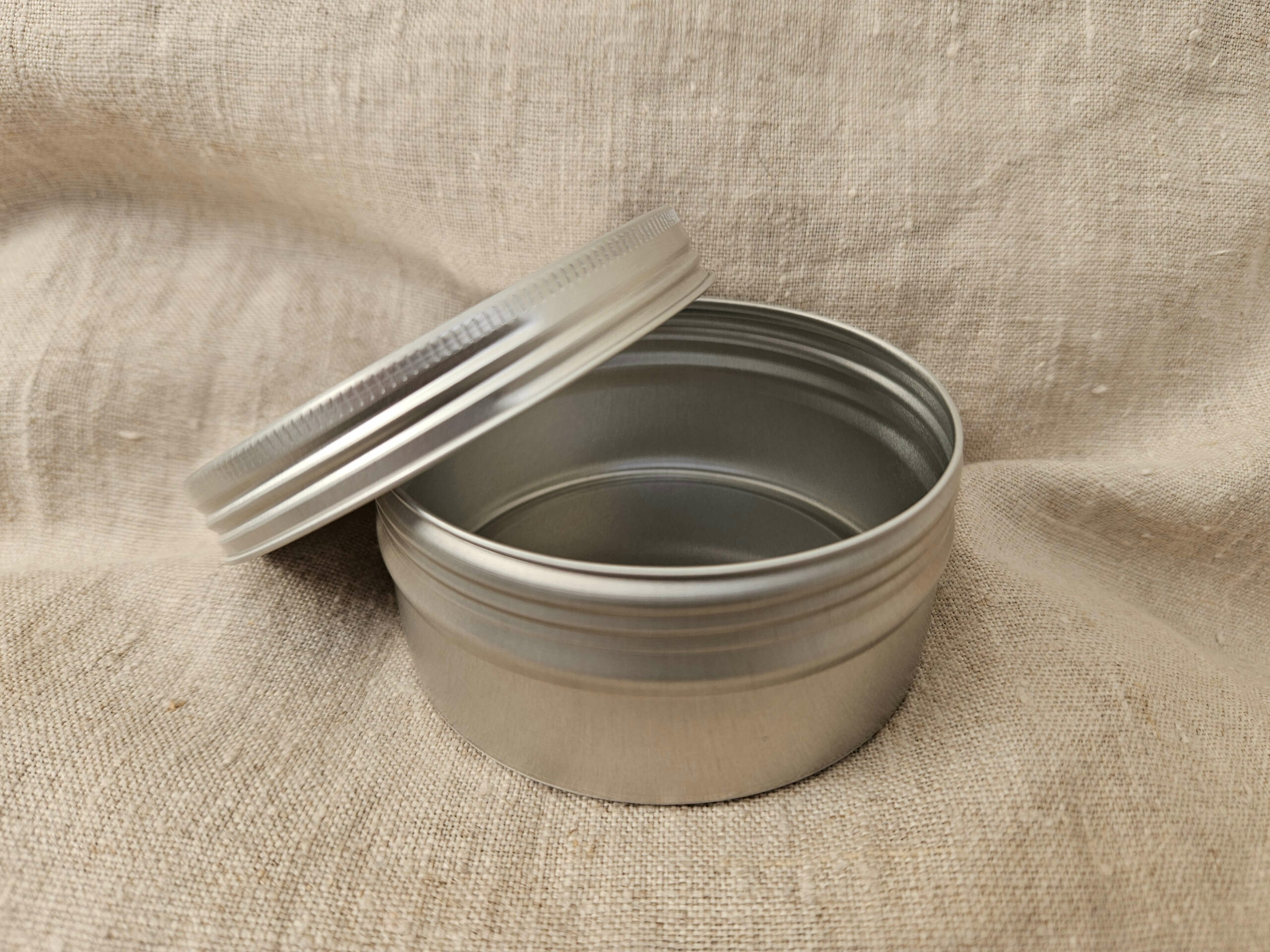 Accessoire zéro déchet de la savonnerie artisanale Sabuni & Cie. Boite ronde en aluminium. Fait en France. Dentifrice sur fond en fibre naturelle. grand modèle
