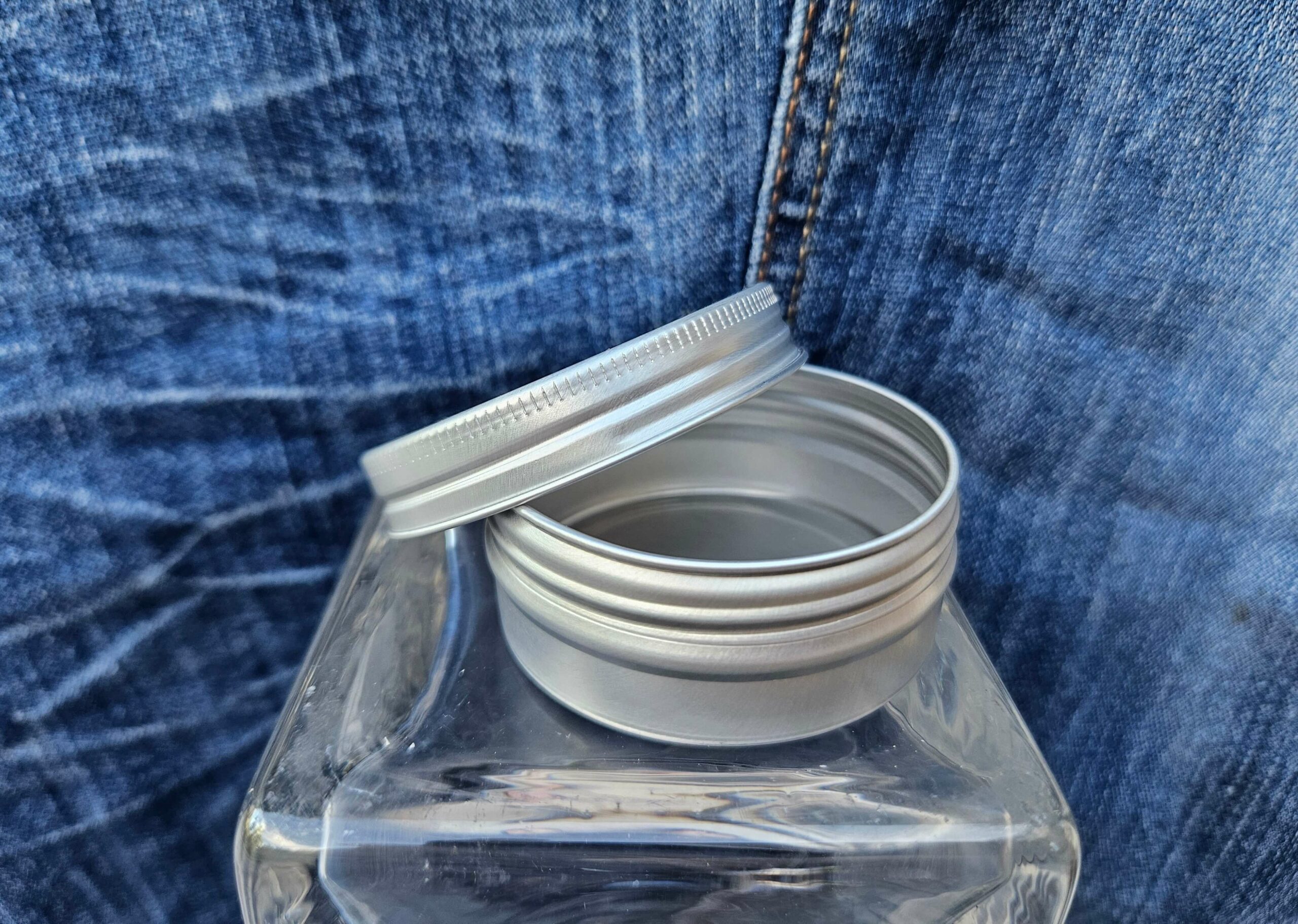 Accessoire zéro déchet de la savonnerie artisanale Sabuni & Cie. Boite ronde en aluminium. Fait en France. Dentifrice sur fond bleu jeans. Petit modèle