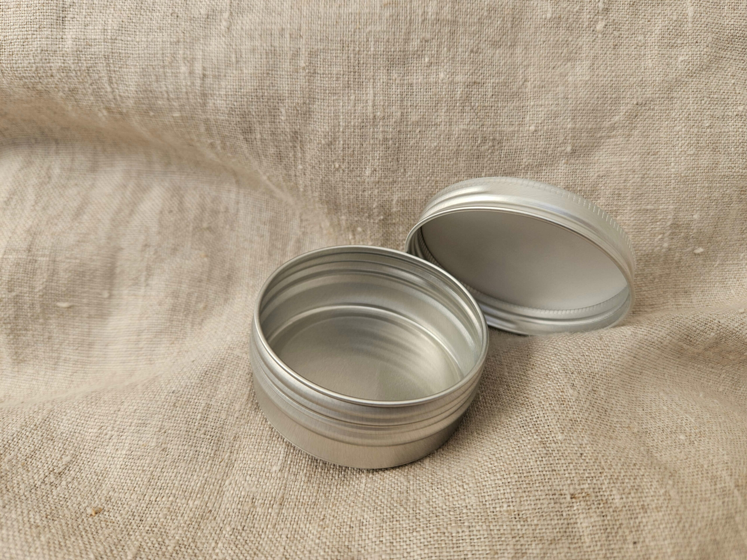 Accessoire zéro déchet de la savonnerie artisanale Sabuni & Cie. Boite ronde en aluminium. Fait en France. Dentifrice sur fond en fibre naturelle. petit modèle