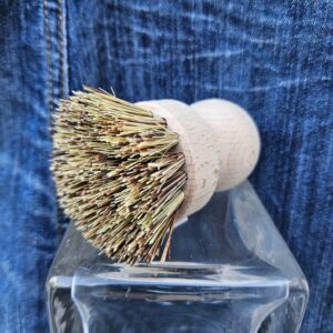 Accessoire zéro déchet de la savonnerie artisanale Sabuni & Cie. Brosse vaisselle fabriquée en Europe. Brosse vaisselle sur fond bleu jeans.