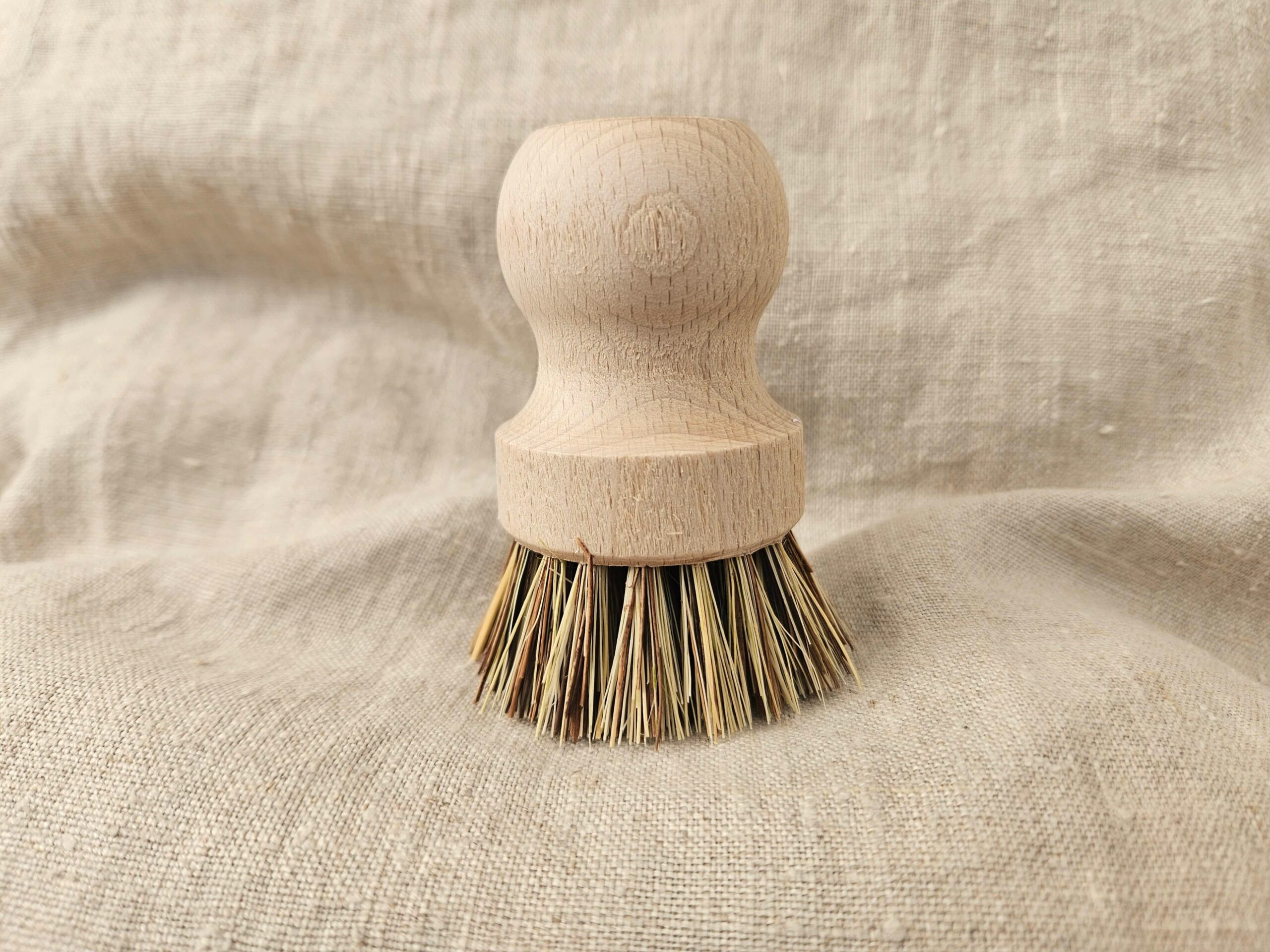 Accessoire zéro déchet de la savonnerie artisanale Sabuni & Cie. Brosse vaisselle fabriquée en Europe. Brosse vaisselle sur fond en fibre naturelle.