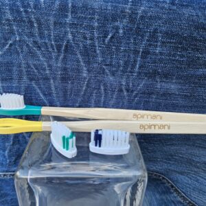 Accessoire zéro déchet de la savonnerie artisanale Sabuni & Cie. Brosse à dents en bois à tête rechargeable. Fait en France. Brosse à dents en bois à tête rechargeable sur fond bleu jeans.