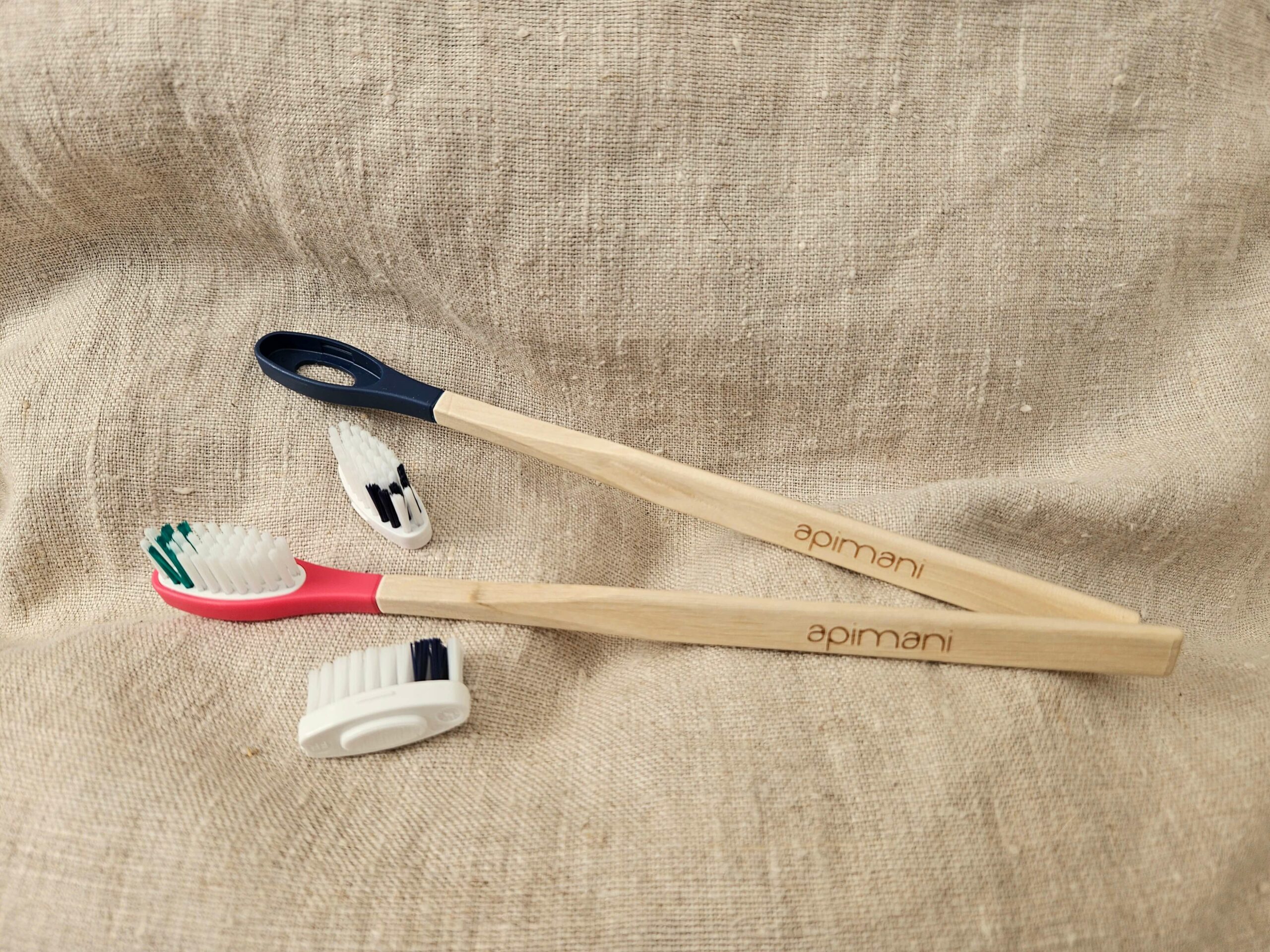 Accessoire zéro déchet de la savonnerie artisanale Sabuni & Cie. Brosse à dents en bois à tête rechargeable. Fait en France. Brosse à dents en bois à tête rechargeable sur fond en fibre naturelle.