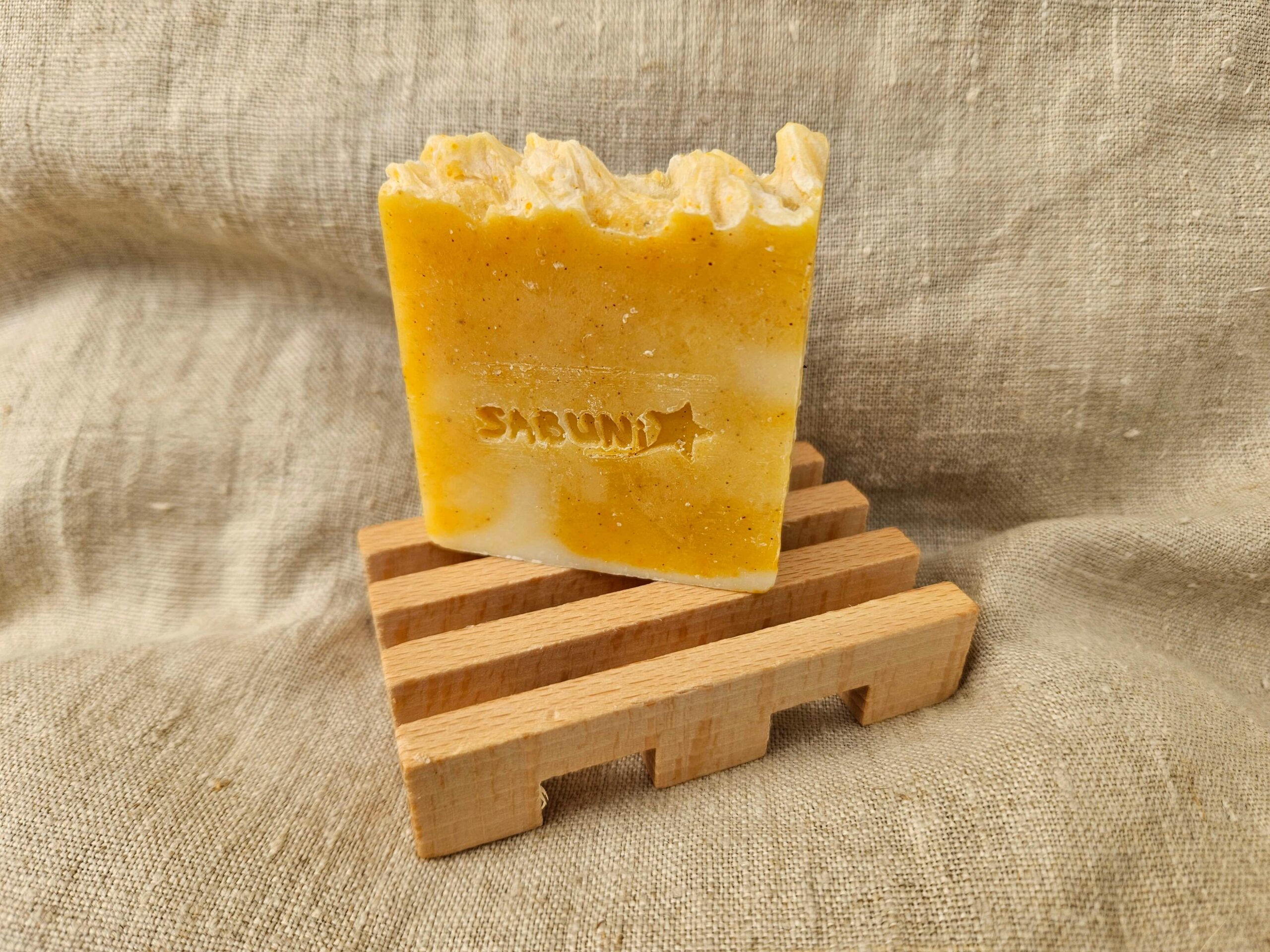 Accessoire zéro déchet de la savonnerie artisanale Sabuni & Cie. Porte savon artisanal en bois massif des Voges et d’Alsace. Porte savon en bois sur fond en fibre naturelle.