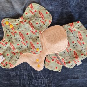 Accessoire zéro déchet de la savonnerie artisanale Sabuni & Cie. Serviettes menstruelles écologiques & solidaires. Fait en France. Protections hygiéniques KA.JI.JI sur fond bleu jeans.